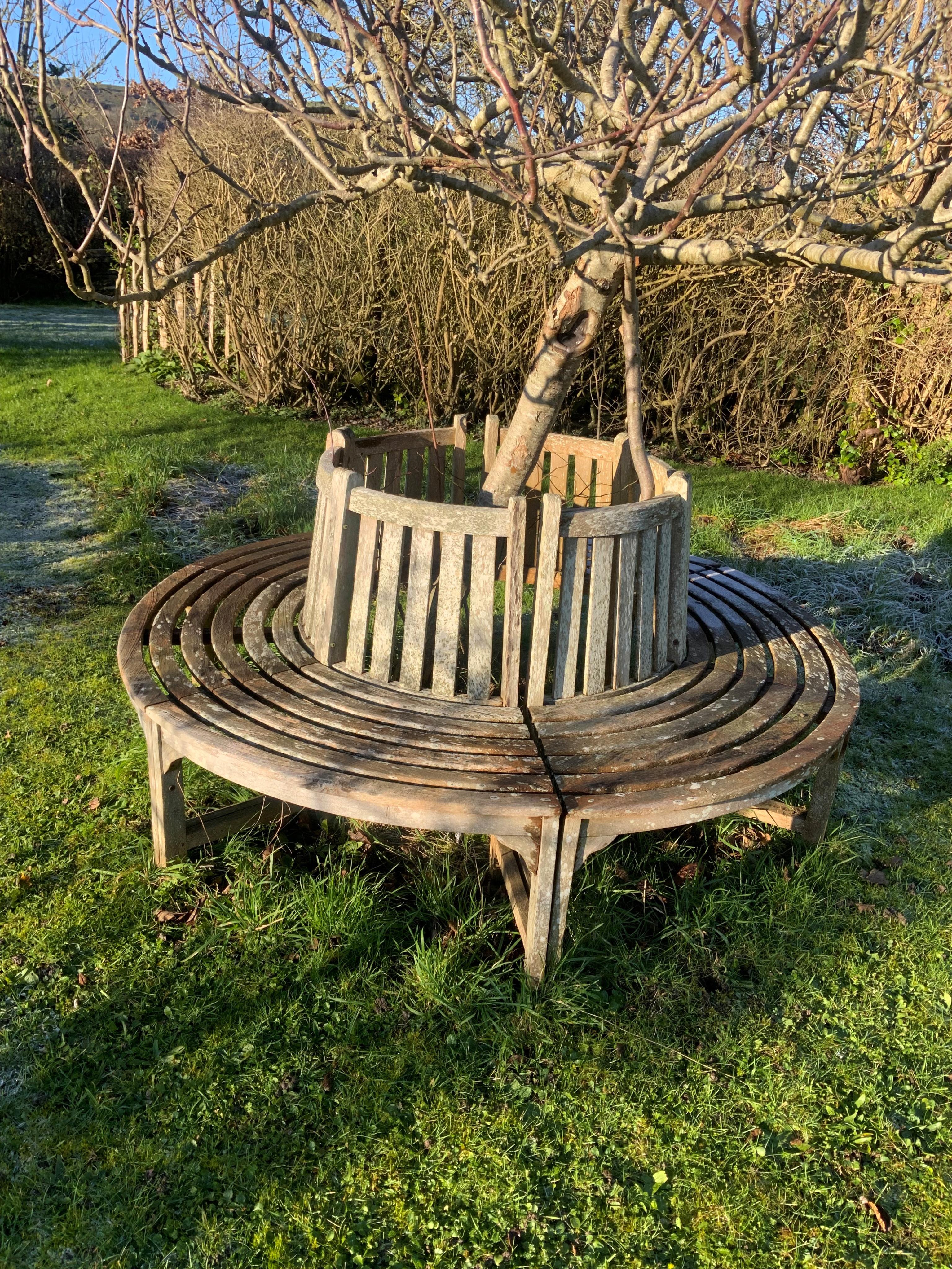 A slatted weathered teak sectional tree surround bench, approx. diameter 190cm, height 87cm. Condition - fair